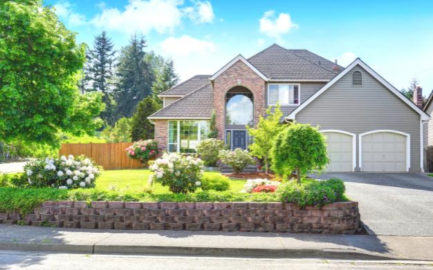 Large house with a gray roof with a background of a garden